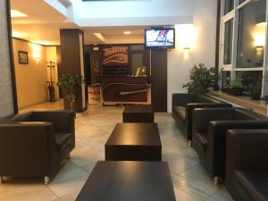 a waiting room with couches and tables and a television at Hotel Iasicon in Lacu Rosu