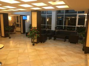 a lobby with a waiting room with black chairs and flowers at Hotel Iasicon in Lacu Rosu