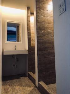 ein Bad mit einem Waschbecken und einem Spiegel in der Unterkunft Good One Poshtel & Cafe Bar in Bangkok
