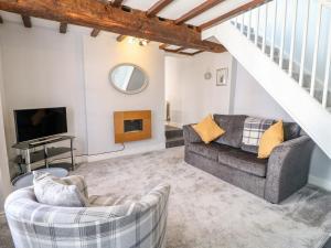 un salon avec un canapé et une télévision dans l'établissement End cottage, à Ashbourne