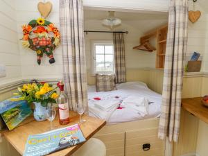 a small bedroom in a tiny house with a bed at Shepherds Hut - The Hurdle in Milford Haven