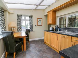 a kitchen with a wooden table and chairs at Stakesby House Apartment 1 in Whitby