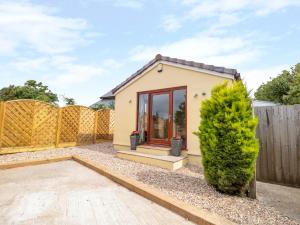 a tiny house in a garden with a fence at Eastdown Annexe in Totnes