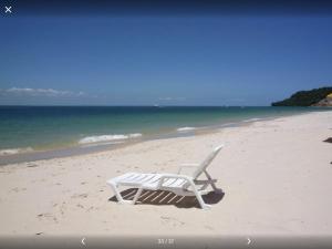 una silla de playa sentada en la arena de la playa en Sitio Oasis en Morro de São Paulo