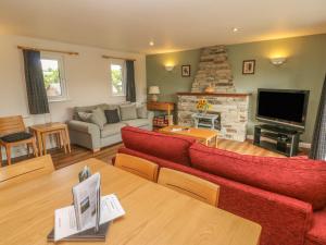 een woonkamer met rode meubels en een open haard bij 64 Waterside in Bodmin