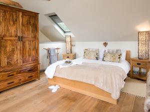 a bedroom with a large bed and wooden floors at Kidcleugh Hide in Duns