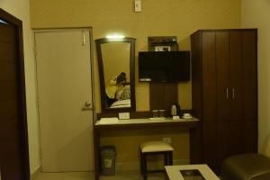 a hotel room with a desk and a mirror at Hotel White Park in Chennai