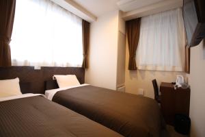 a hotel room with two beds and a window at Hotel Trend Tobu Asakusa-Eki Kita in Tokyo
