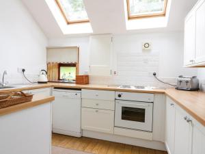 uma cozinha com armários brancos e uma clarabóia em Cardean Mill em Blairgowrie
