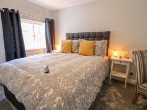 - une chambre avec un lit doté d'une télécommande dans l'établissement End cottage, à Ashbourne