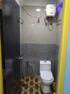 a bathroom with a toilet and a camera on the wall at Gayathri Stay in Kanchipuram