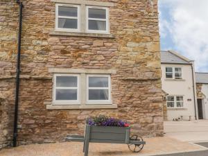 a stone building with a flower box in front of it at The Barn in Workington