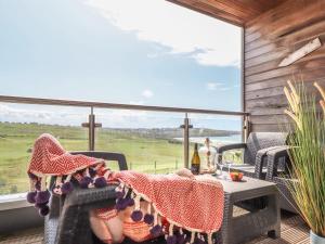 un patio con mesa, sillas y una ventana grande en 8 Cribbar en Newquay