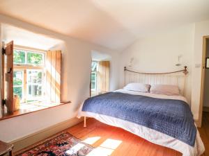 een slaapkamer met een groot bed en een raam bij Heather Cottage in Penzance