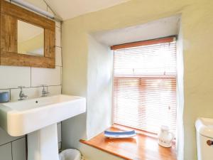 een badkamer met een wastafel en een raam bij Heather Cottage in Penzance +22 foto's