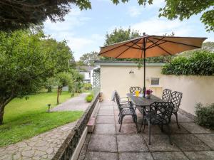 a table and chairs with an umbrella on a patio at The Roost in Camborne