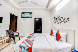 a bedroom with a bed and a desk and a tv at FabHotel Himanshi in Udaipur