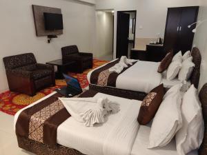 een hotelkamer met 2 bedden en een televisie bij Chandra Inn in Jodhpur