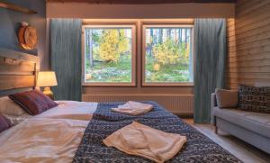 a bedroom with a bed and a couch and two windows at Jeris Lakeside Resort in Muonio