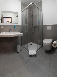 a bathroom with a shower and a toilet and a sink at Hotel Schlafplatz in Rodgau