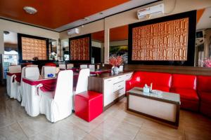 a restaurant with red and white chairs and a table at RedDoorz Plus near DC Mall Batam in Nagoya