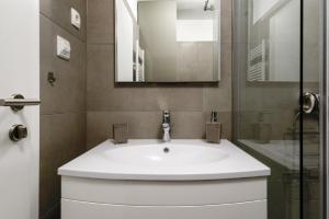 a bathroom with a white sink and a mirror at Donatus - Modern apartment near the bridge/centre in Zadar