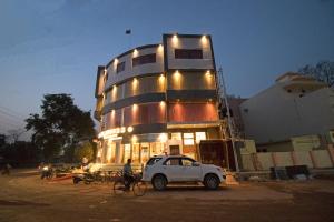 a white car parked in front of a building at Hotel Vagmi in Varanasi