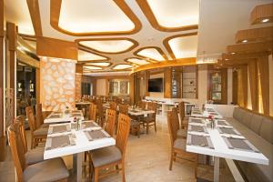 a dining room with white tables and chairs at Hotel Vagmi in Varanasi