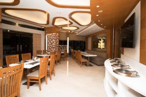 a dining room with tables and chairs in a restaurant at Hotel Vagmi in Varanasi