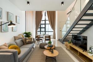 a living room with a couch and a tv at Eko Cheras Premium Suite in Kuala Lumpur