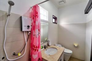 a bathroom with a pink shower curtain and a sink at ABC Apartment Sanur in Sanur +42 photos