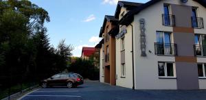 a car parked in a parking lot next to a building at Dom Goscinny Skarpa in Krynica Zdrój