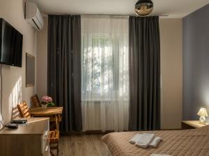 a hotel room with a bed and a window at Simada Green Guesthouse in Varshets