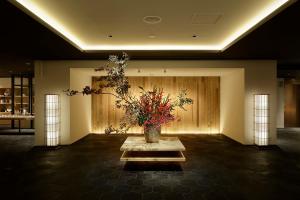a large room with a vase with flowers in it at hotel kanra kyoto in Kyoto