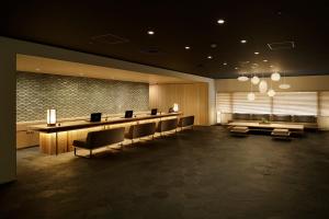 京都市にあるhotel kanra kyotoの長いテーブルと椅子が備わる待合室