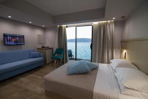 a bedroom with a large bed and a blue couch at Aianteion Bay Luxury Hotel & Suites in Aiándion