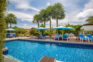 a swimming pool with blue chairs and umbrellas at Sungthong Kamala Beach Resort in Kamala Beach