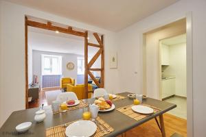 einen Tisch mit Teller Essen darauf im Wohnzimmer in der Unterkunft Bica Apartment in Lissabon