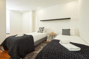 ein Schlafzimmer mit 2 Betten und einem Tisch darin in der Unterkunft Bica Apartment in Lissabon
