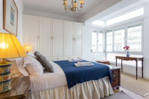 1 dormitorio con cama, lámpara y mesa en Carcavelos - Holiday Beach Apartment en Carcavelos