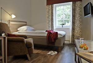 フッディンゲにあるBalingsholmのベッドルーム1室(ベッド1台、ソファ、窓付)
