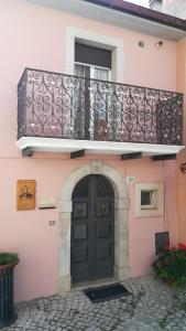ScontroneにあるDon Pasquale Scontrone Houseのピンクの建物(黒いドア、バルコニー付)