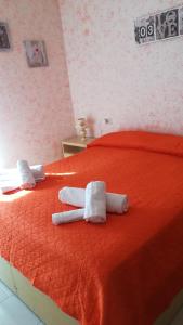 Una cama roja con dos toallas enrolladas. en Don Pasquale Scontrone House, en Scontrone