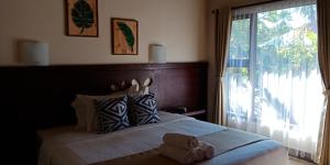 een slaapkamer met een bed en een groot raam bij Zifa Kuta Lombok in Kuta Lombok