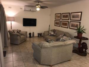 a living room with two couches and a flat screen tv at Villa Danamara in Phalaborwa