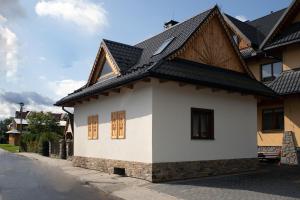 a white house with a black roof at Domek u Bronka in Białka Tatrzanska