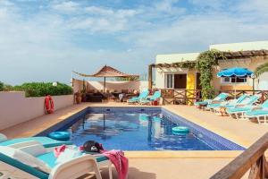 a swimming pool with lounge chairs and a swimming pool at Aftas Trip in Mirleft
