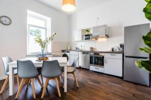a kitchen with a table and chairs in a room at Adora Apartment Hilden in Hilden