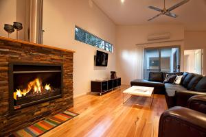 uma sala de estar com um sofá e uma lareira em Vintners - more space for you to enjoy! em Quindalup