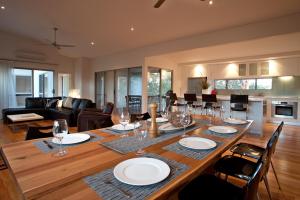 uma mesa de jantar com pratos e copos de vinho em Vintners - more space for you to enjoy! em Quindalup